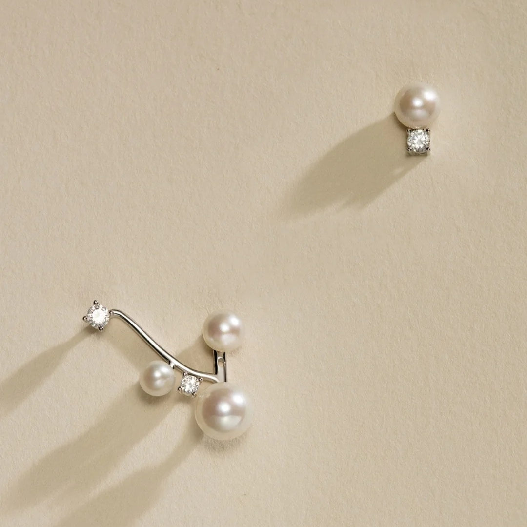 Pearl and diamond earrings on a beige background