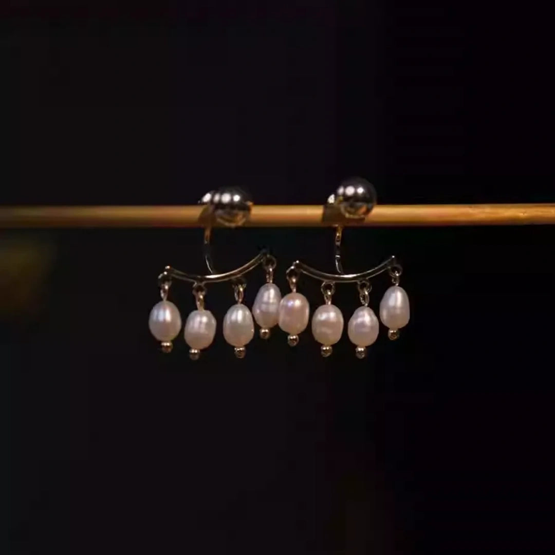 Close-up of baroque pearl fringe earrings with gold-plated copper base