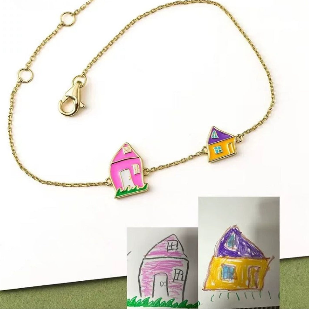 Bracelet with house-shaped charms next to children's drawings of houses