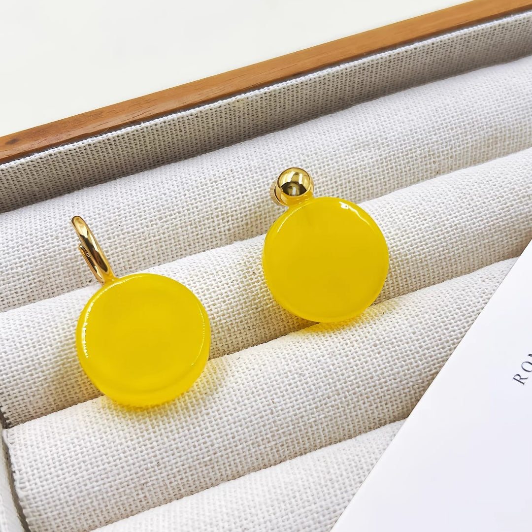 Yellow glass earrings displayed in a luxury linen-lined jewelry organizer tray.