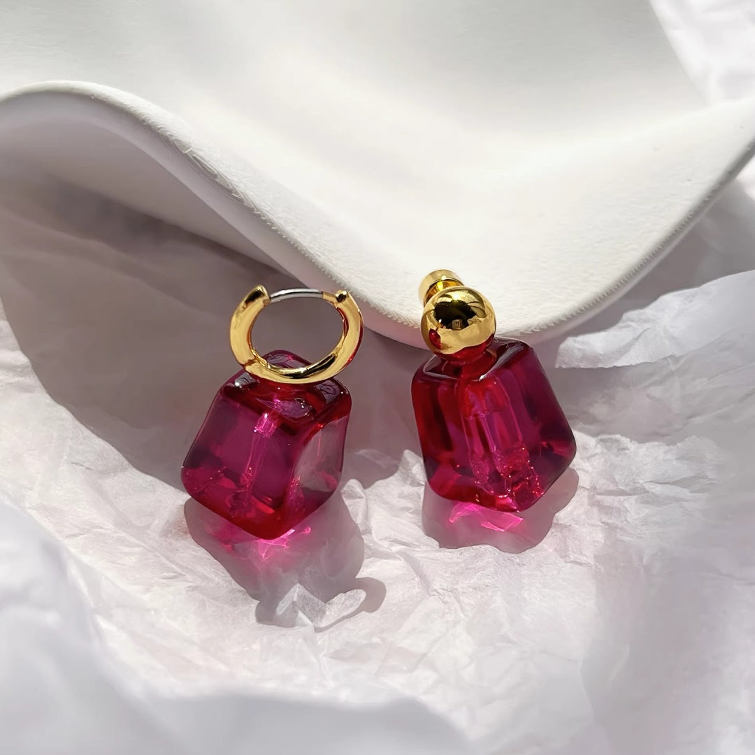 Two styles of magenta statement earrings: hoops and studs comparison.
