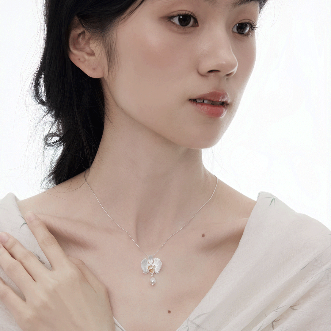 Botanical Realism Elegant pearl orchid necklace highlighting the collarbone area for professional wear.
