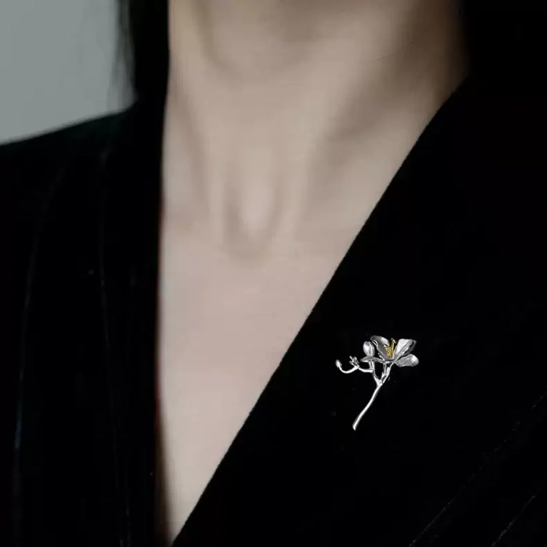 Model wearing the silver freesia flower branch brooch on a black velvet blazer for a professional look.