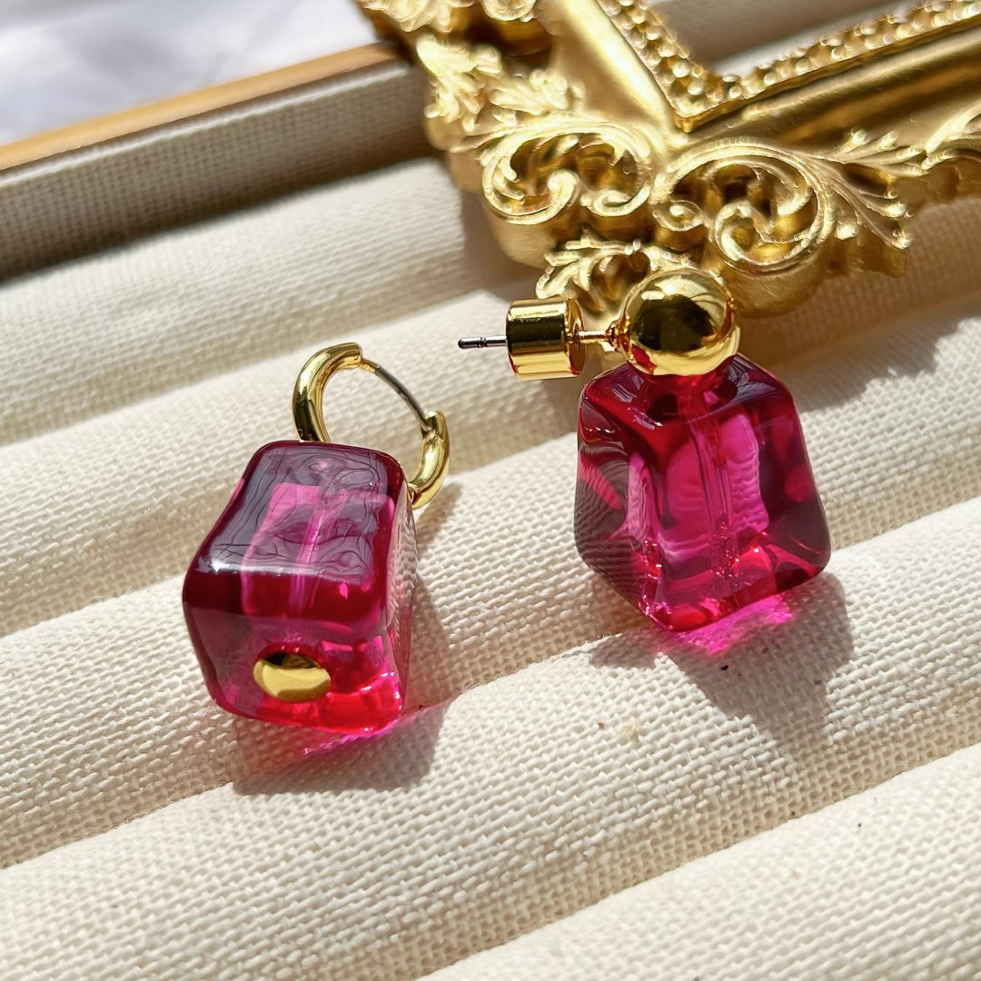 Close-up of the irregular 'ice cube' facets on magenta glass jewelry.