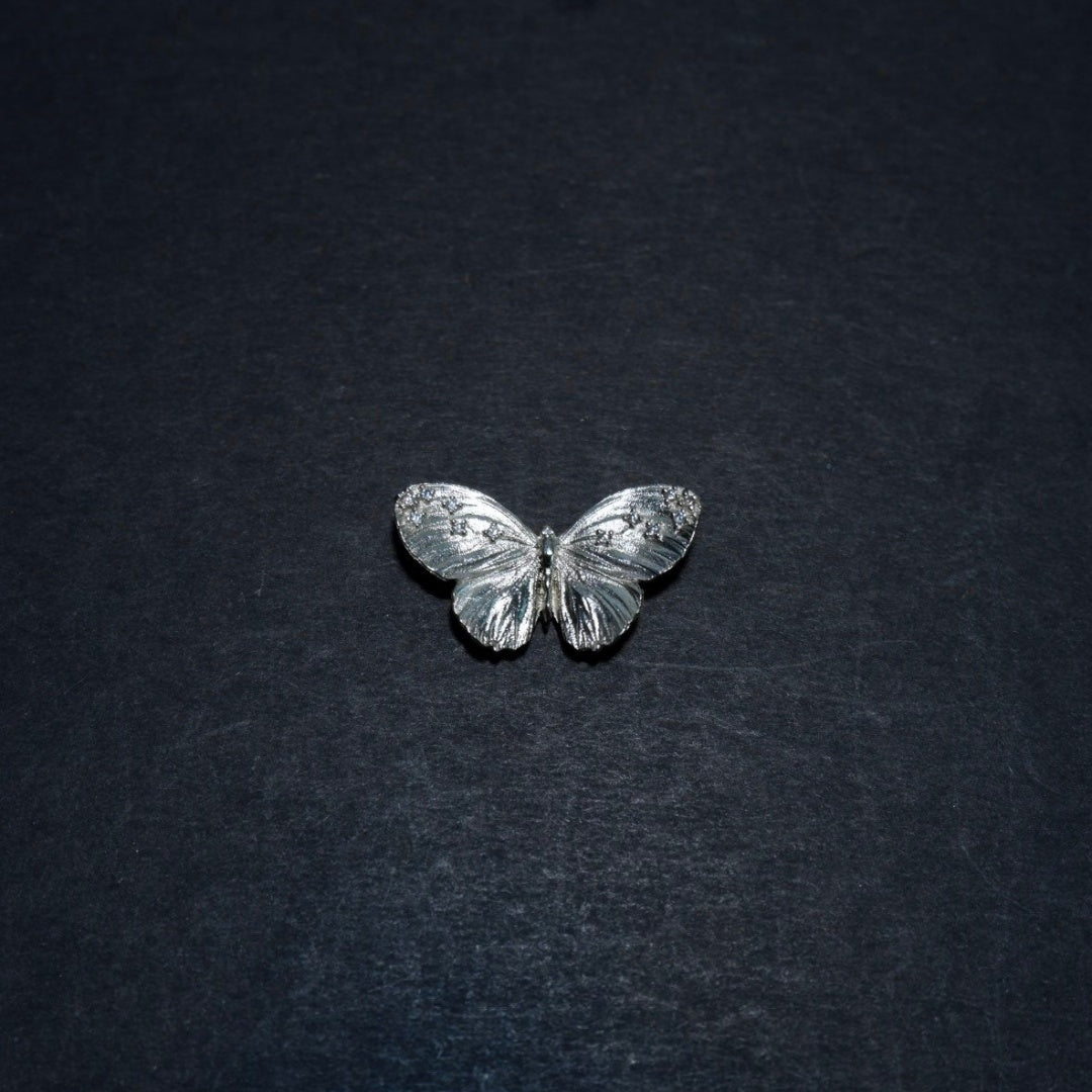 Close-up of the textured wing butterfly pendant in S925 sterling silver against a dark background - product-studio-2