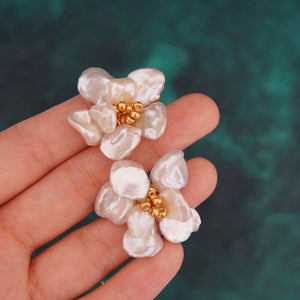 A pair of handcrafted pearl flower stud earrings featuring baroque freshwater pearls and gold bead accents in the center. These dainty pearl flower earrings are perfect bridal flower earrings and floral wedding earrings, making them an elegant choice for statement wedding bridal jewelry.