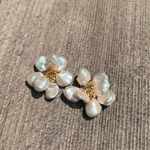 A pair of handcrafted pearl flower stud earrings featuring baroque freshwater pearls and gold bead accents in the center. These dainty pearl flower earrings are perfect bridal flower earrings and floral wedding earrings, making them an elegant choice for statement wedding bridal jewelry.