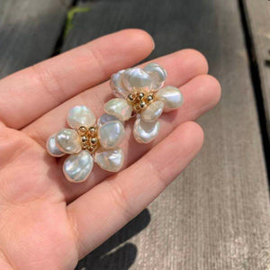 A pair of handcrafted pearl flower stud earrings featuring baroque freshwater pearls and gold bead accents in the center. These dainty pearl flower earrings are perfect bridal flower earrings and floral wedding earrings, making them an elegant choice for statement wedding bridal jewelry.