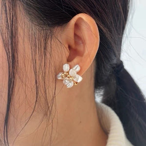 A pair of handcrafted pearl flower stud earrings featuring baroque freshwater pearls and gold bead accents in the center. These dainty pearl flower earrings are perfect bridal flower earrings and floral wedding earrings, making them an elegant choice for statement wedding bridal jewelry.