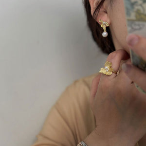 Close-up of Flower Statement Earrings featuring freshwater pearl statement earrings and three sparkling diamonds, perfect as bridal pearl statement earrings and Gold pearl earrings for a statement pearl earrings wedding look.