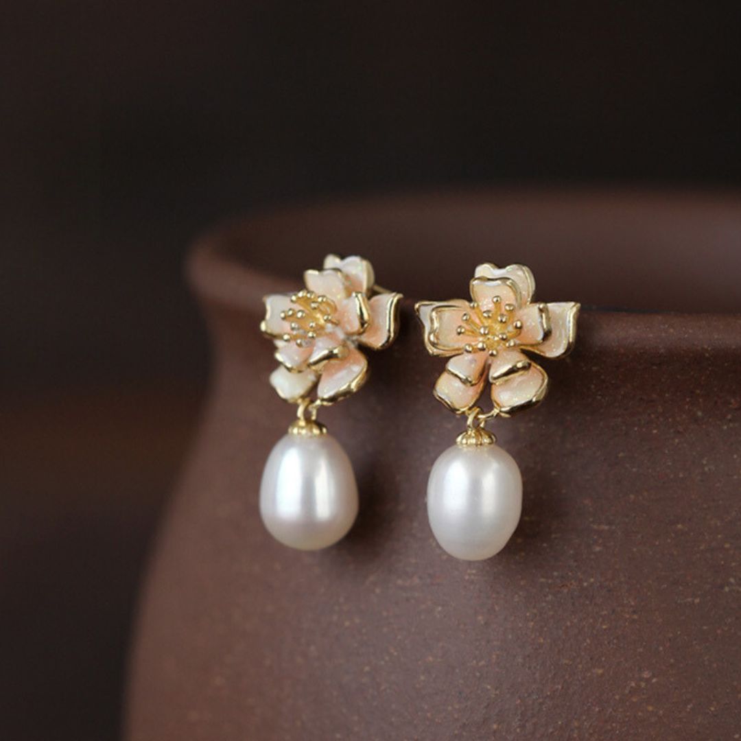 Close-up of gold sakura charm earrings featuring pink petals and pearls, designed as sakura pearl earrings and Flower Stud Earrings—perfect for Cottage core earrings and Cherry Blossom Earrings styles.