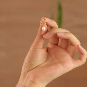 Close-up of gold sakura charm earrings featuring pink petals and pearls, designed as sakura pearl earrings and Flower Stud Earrings—perfect for Cottage core earrings and Cherry Blossom Earrings styles.