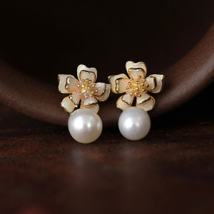 Close-up of gold sakura charm earrings featuring pink petals and pearls, designed as sakura pearl earrings and Flower Stud Earrings—perfect for Cottage core earrings and Cherry Blossom Earrings styles.