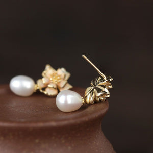 Close-up of gold sakura charm earrings featuring pink petals and pearls, designed as sakura pearl earrings and Flower Stud Earrings—perfect for Cottage core earrings and Cherry Blossom Earrings styles.