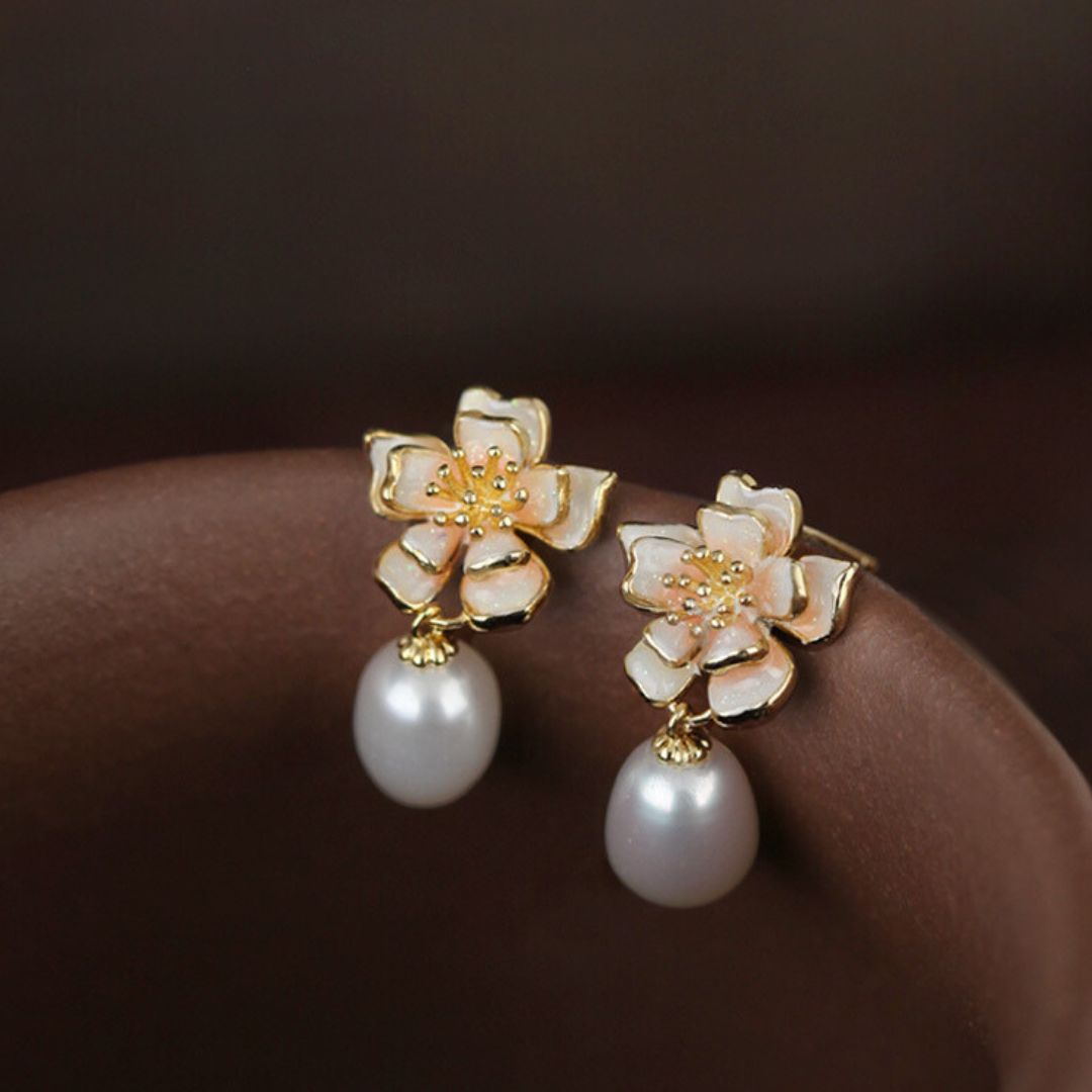 Close-up of gold sakura charm earrings featuring pink petals and pearls, designed as sakura pearl earrings and Flower Stud Earrings—perfect for Cottage core earrings and Cherry Blossom Earrings styles.