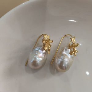 A pair of delicate gold iris flower pearl earrings with intricate flower detailing, symbolizing wisdom and hope, paired with lustrous Freshwater Cultured Pearls, ideal for a wedding or formal event.