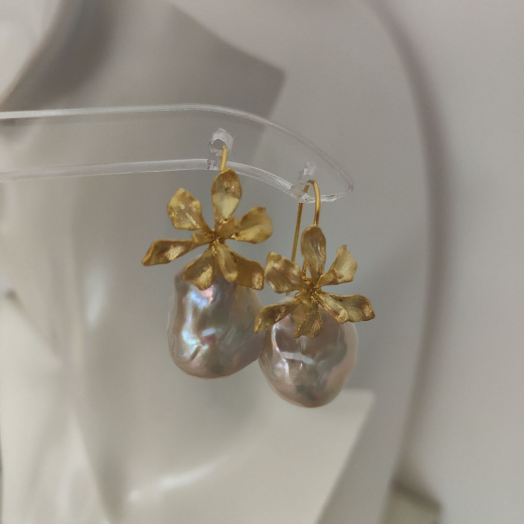 A pair of delicate gold iris flower pearl earrings with intricate flower detailing, symbolizing wisdom and hope, paired with lustrous Freshwater Cultured Pearls, ideal for a wedding or formal event.