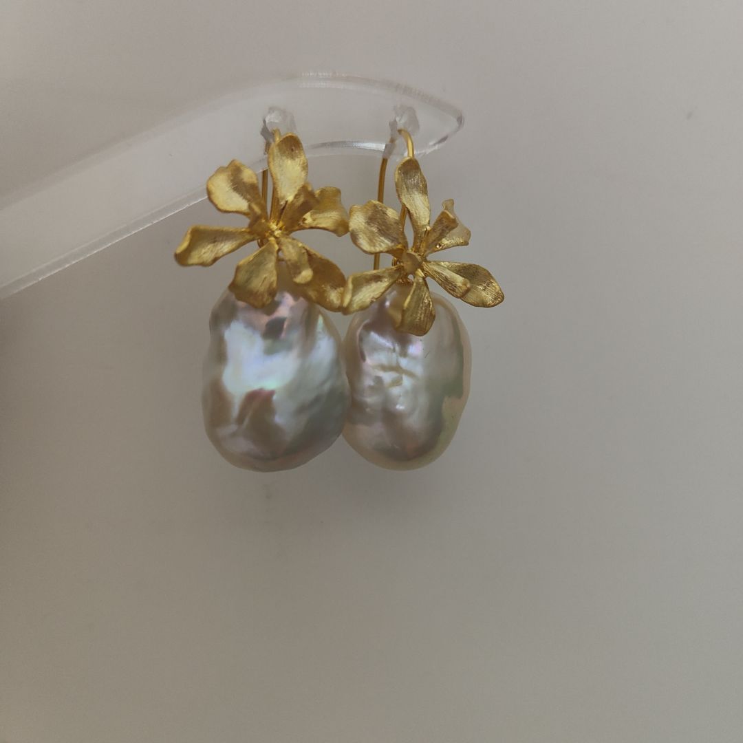 A pair of delicate gold iris flower pearl earrings with intricate flower detailing, symbolizing wisdom and hope, paired with lustrous Freshwater Cultured Pearls, ideal for a wedding or formal event.