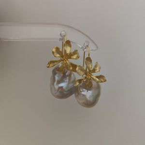 A pair of delicate gold iris flower pearl earrings with intricate flower detailing, symbolizing wisdom and hope, paired with lustrous Freshwater Cultured Pearls, ideal for a wedding or formal event.