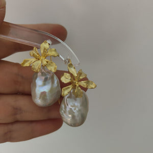 A pair of delicate gold iris flower pearl earrings with intricate flower detailing, symbolizing wisdom and hope, paired with lustrous Freshwater Cultured Pearls, ideal for a wedding or formal event.