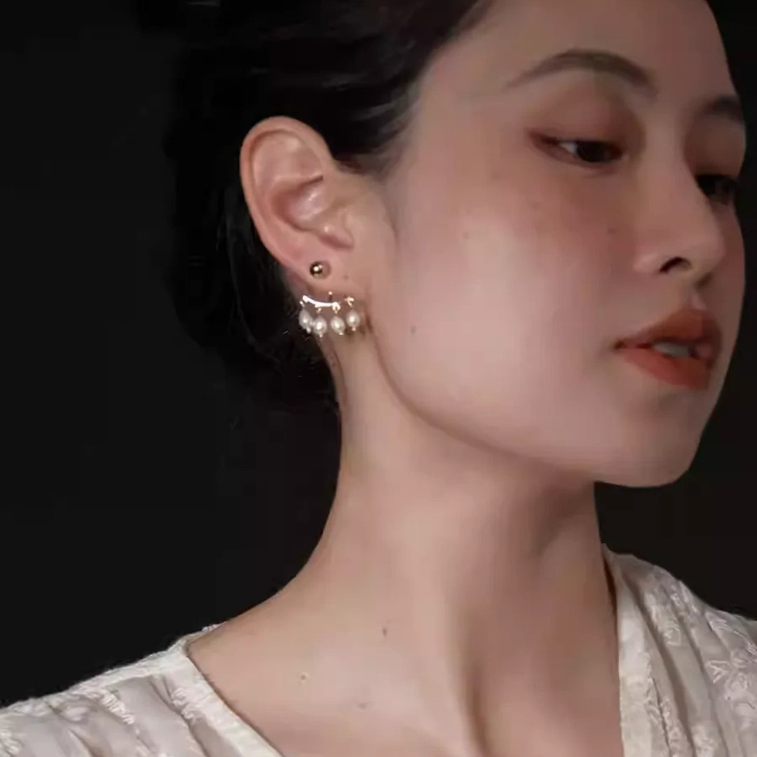 Side view of gold and pearl tassel earrings showcasing the ear jacket structure