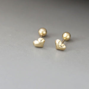 A pair of tiny gold heart studs with a delicate, minimalist design. These gold heart stud earrings showcase a classic Korean jewelry style, perfect for everyday wear.