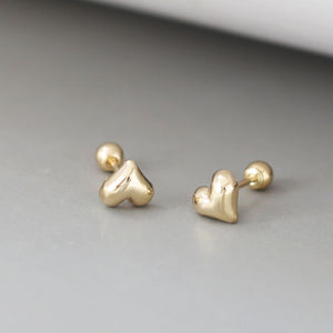 A pair of tiny gold heart studs with a delicate, minimalist design. These gold heart stud earrings showcase a classic Korean jewelry style, perfect for everyday wear.