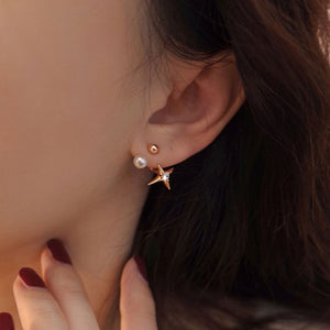 Dainty gold star stud earrings featuring a starburst design with a freshwater pearl, combining celestial elegance with vintage charm.