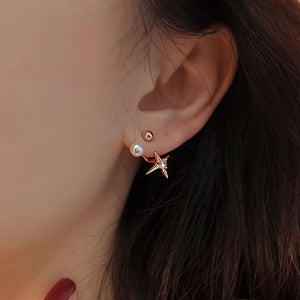 Dainty gold star stud earrings featuring a starburst design with a freshwater pearl, combining celestial elegance with vintage charm.