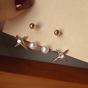 Dainty gold star stud earrings featuring a starburst design with a freshwater pearl, combining celestial elegance with vintage charm.