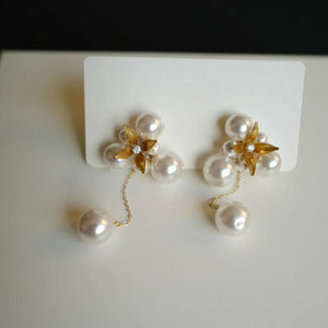 A pair of handcrafted vintage pearl flower earrings with a central gold flower surrounded by delicate pearls. The earrings feature a removable dangle, allowing them to be worn as pearl flower stud earrings or pearl cluster drop earrings. Perfect for brides, these dainty pearl flower earrings are ideal for floral wedding earrings or bridal flower earrings, offering versatile statement wedding bridal jewelry.