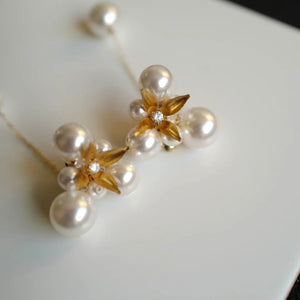 A pair of handcrafted vintage pearl flower earrings with a central gold flower surrounded by delicate pearls. The earrings feature a removable dangle, allowing them to be worn as pearl flower stud earrings or pearl cluster drop earrings. Perfect for brides, these dainty pearl flower earrings are ideal for floral wedding earrings or bridal flower earrings, offering versatile statement wedding bridal jewelry.