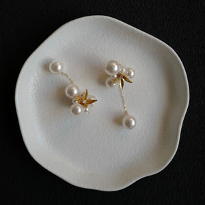 A pair of handcrafted vintage pearl flower earrings with a central gold flower surrounded by delicate pearls. The earrings feature a removable dangle, allowing them to be worn as pearl flower stud earrings or pearl cluster drop earrings. Perfect for brides, these dainty pearl flower earrings are ideal for floral wedding earrings or bridal flower earrings, offering versatile statement wedding bridal jewelry.