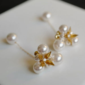 A pair of handcrafted vintage pearl flower earrings with a central gold flower surrounded by delicate pearls. The earrings feature a removable dangle, allowing them to be worn as pearl flower stud earrings or pearl cluster drop earrings. Perfect for brides, these dainty pearl flower earrings are ideal for floral wedding earrings or bridal flower earrings, offering versatile statement wedding bridal jewelry.