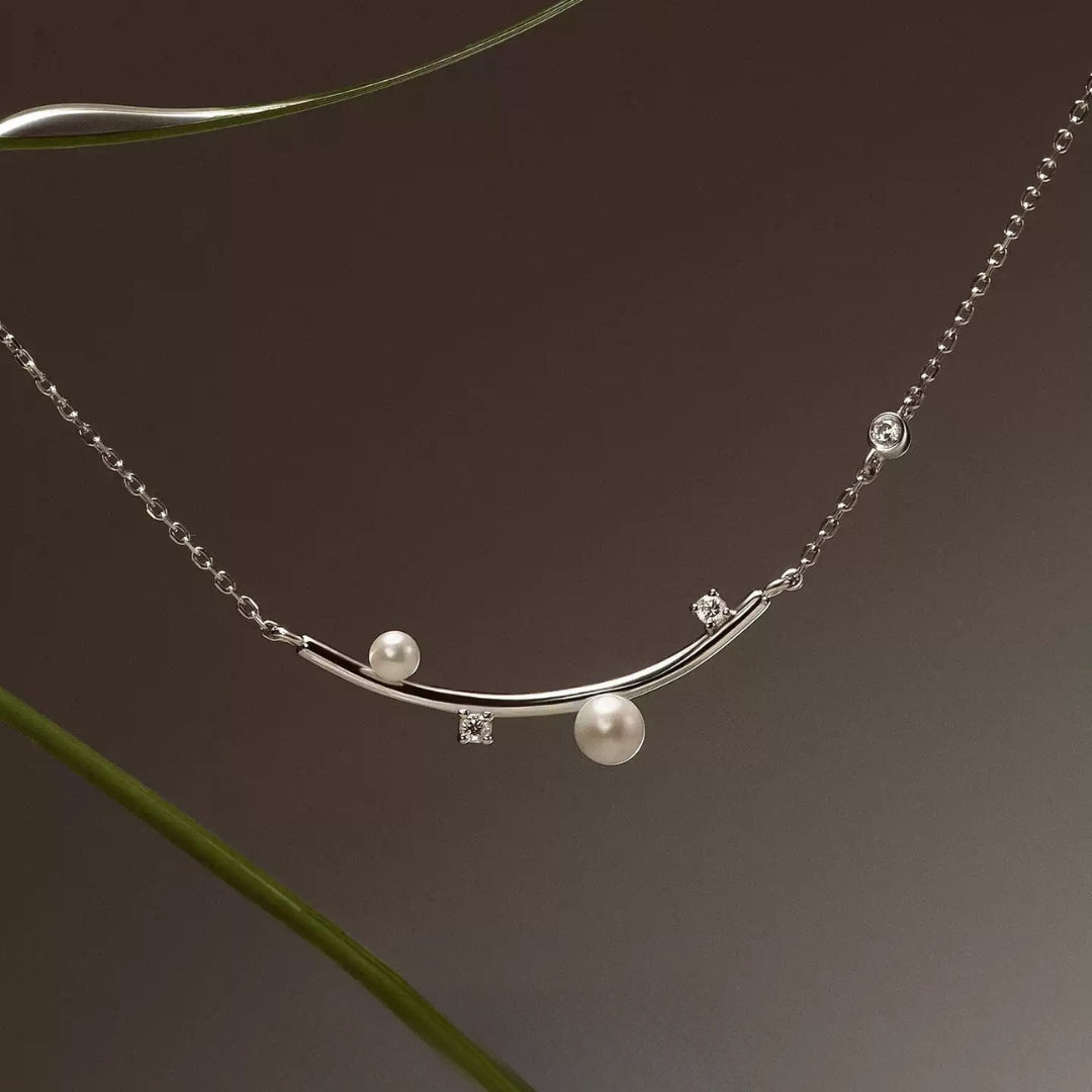 A close up of a silver diamond necklace.