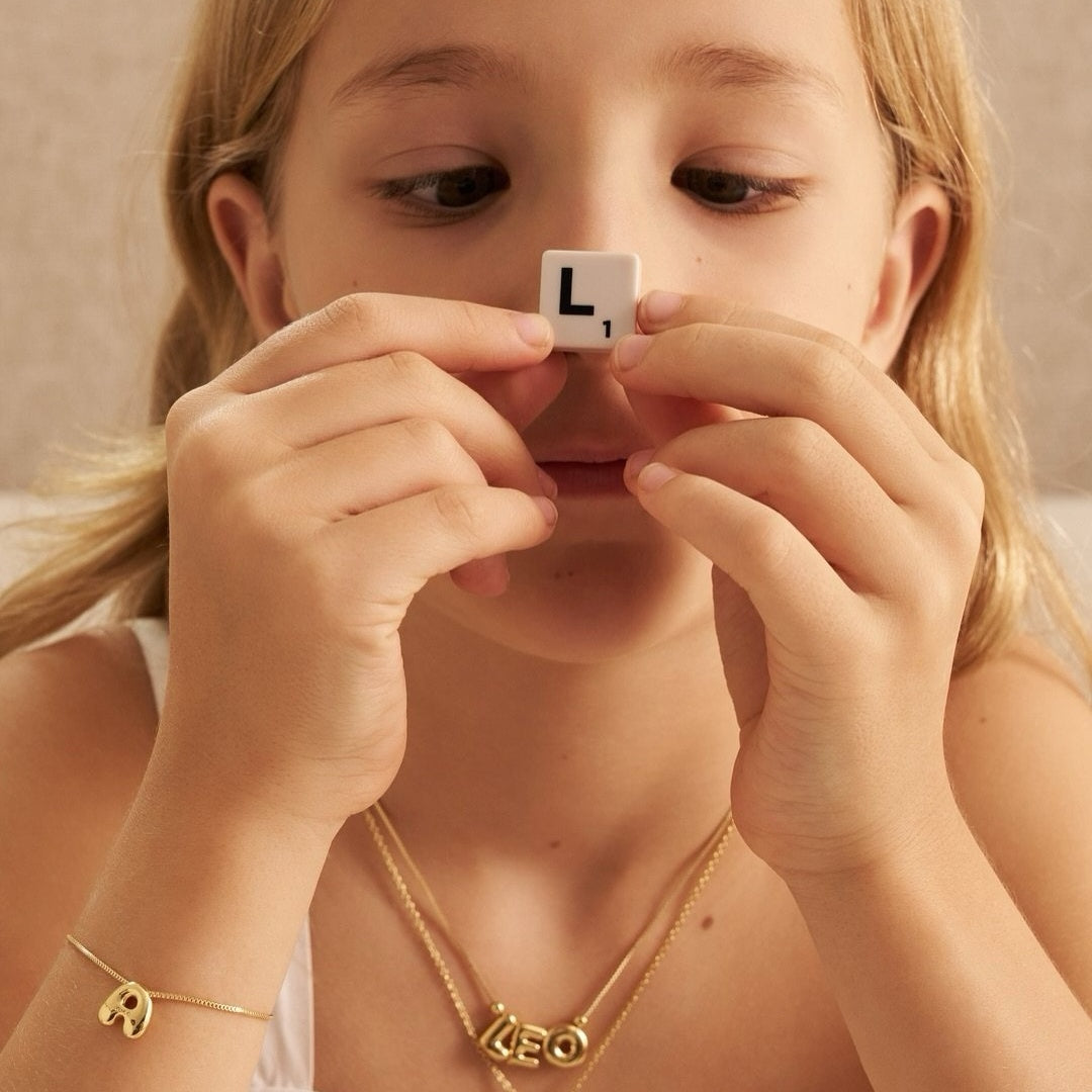 Size reference of mini 1cm 3D puffed initial pendant in polished gold finish.1