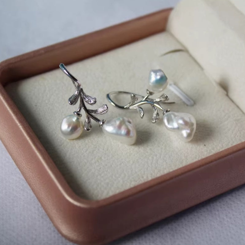 Silver-toned baroque pearl leaf earrings displayed in a luxury pink jewelry gift box.